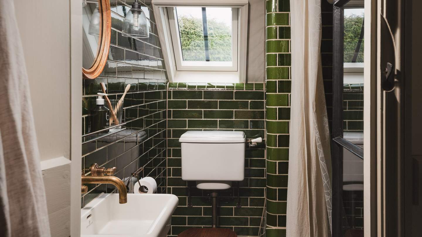 An exquisite bathroom with underfloor heating resides between the two bedrooms, with stunning Victorian tiles, brass inflections, and a walk-in shower