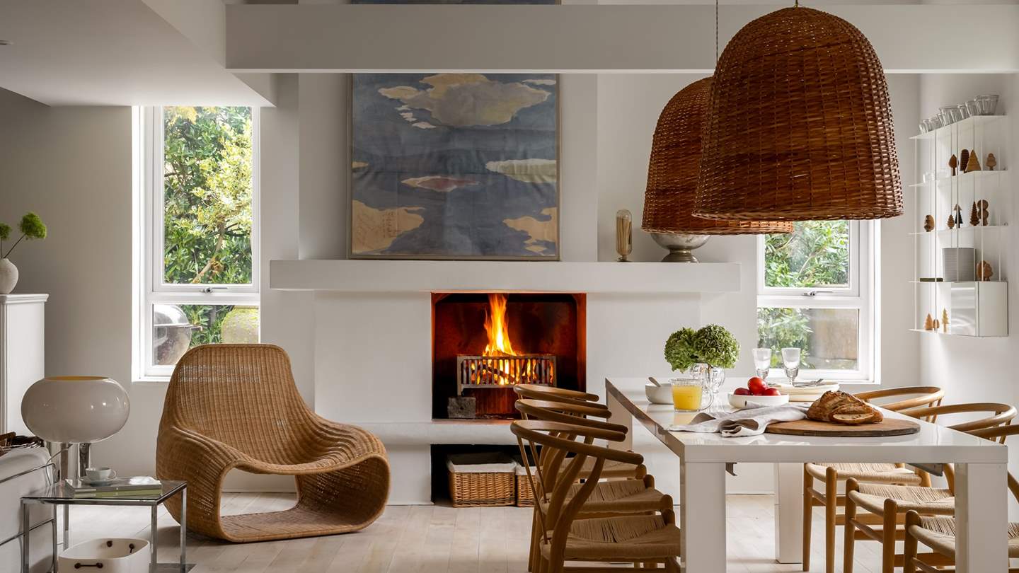 Scandi-style wishbone chairs position beneath two large hand woven pendant lights, a dream space to dine