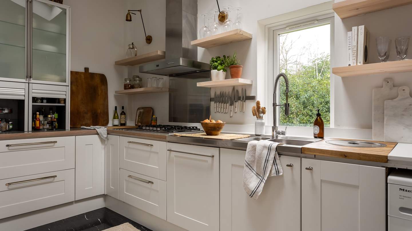 Craft culinary delights in the modern shaker style kitchen with whitewashed open shelving