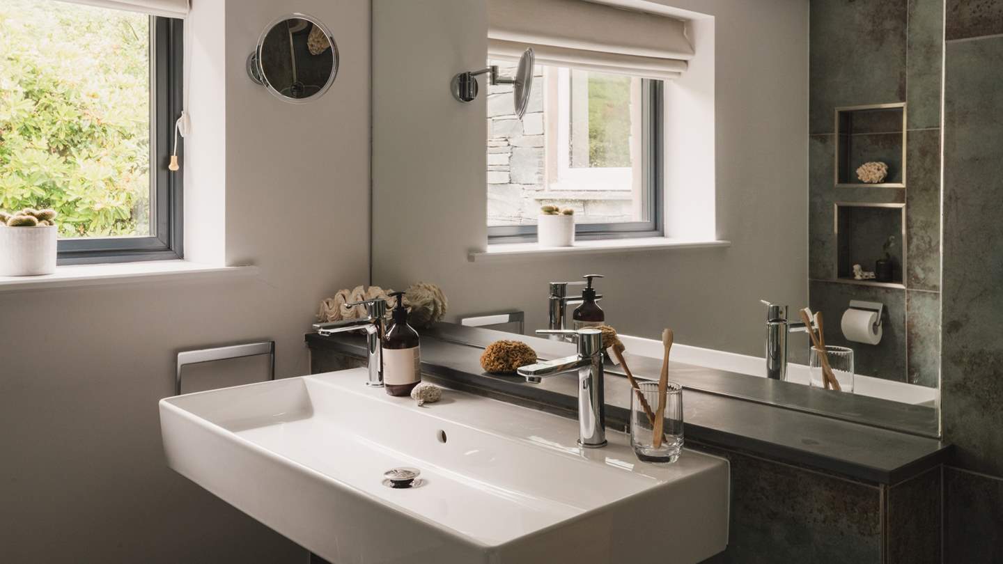 A dual sink is positioned before a large mirror - perfect for your morning self-care rituals 
