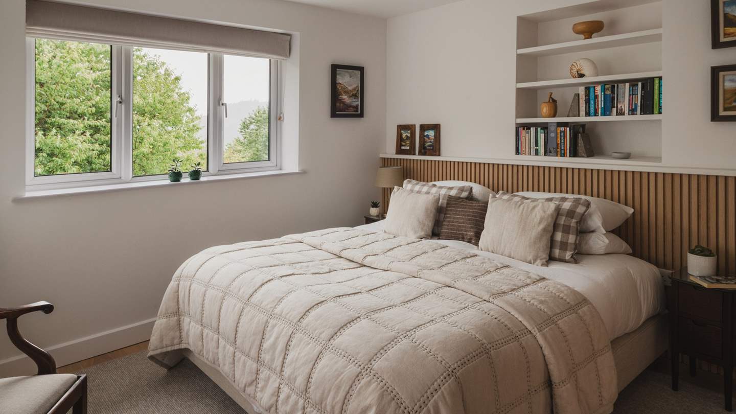 The fourth bedroom features a wooden slat headboard and alcove library