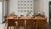 At the far side of the kitchen and nestled before a large Lakeland gallery wall, an oak dining table for ten awaits