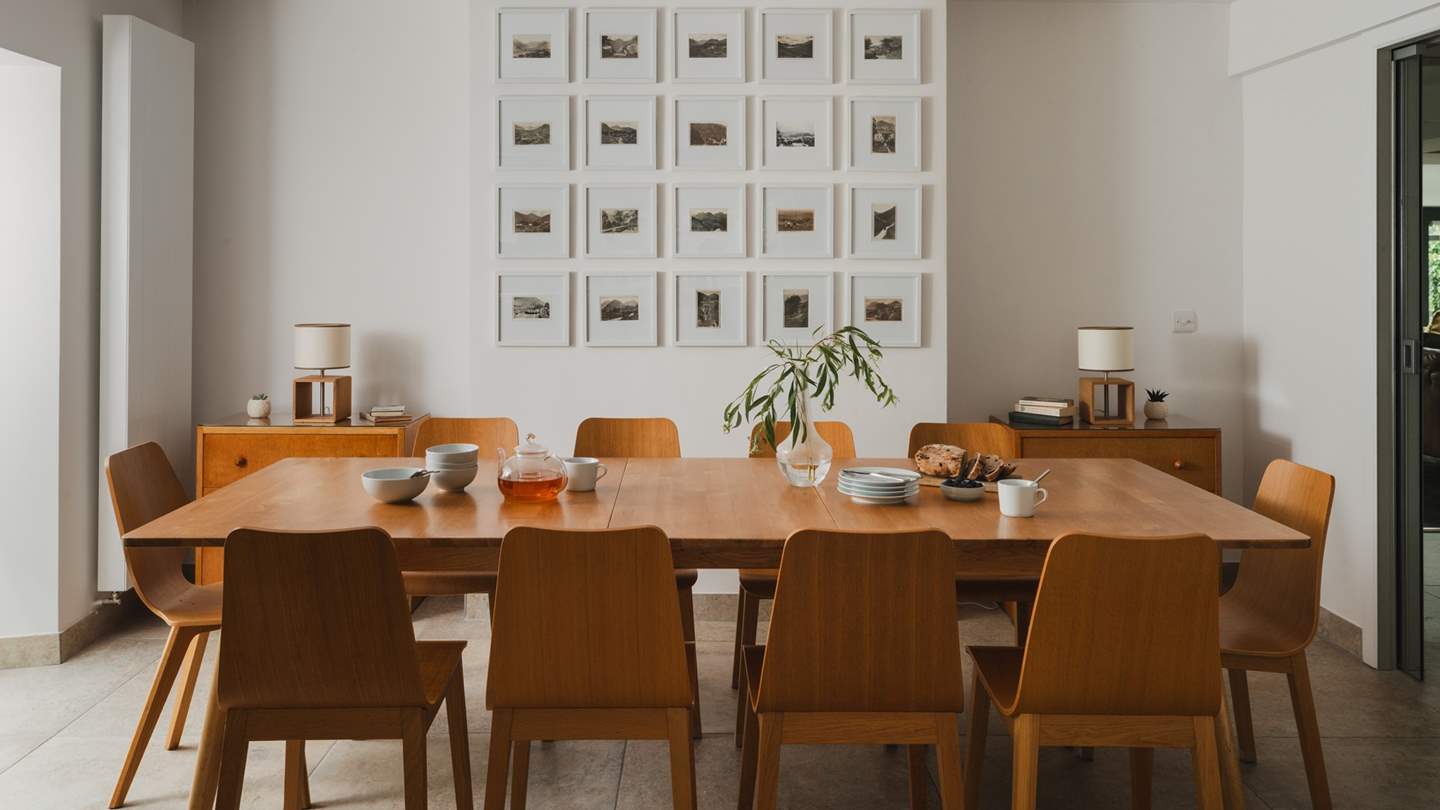 At the far side of the kitchen and nestled before a large Lakeland gallery wall, an oak dining table for ten awaits