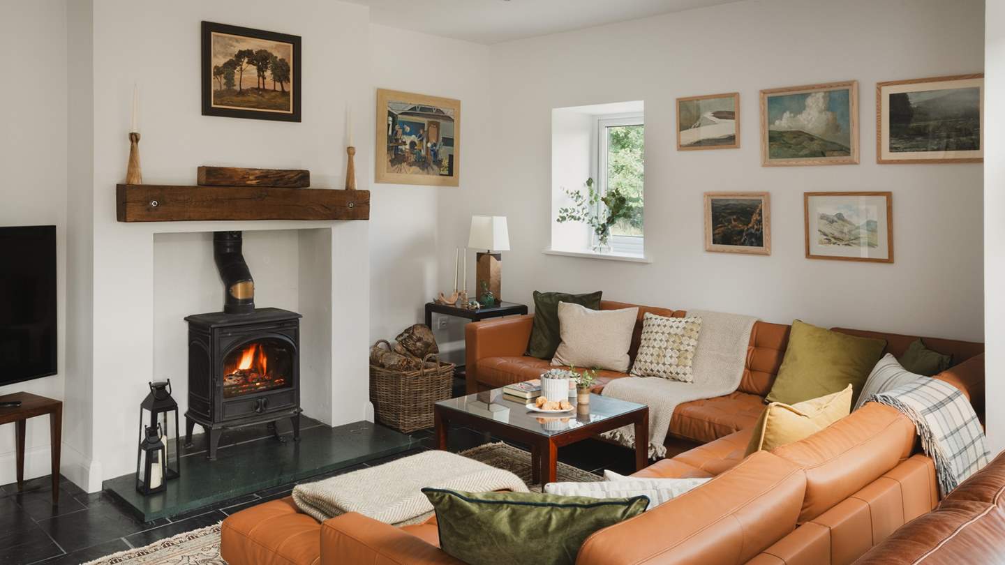 A second wood burning stove can be found before a large leather U-shaped sofa