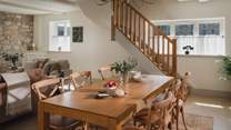 The solid oak dining table with six mid-century inspired cottage chairs is a delightful setting for staycation suppers