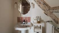 The en suite promises a glossy peach pink tiled walk-in shower with a rainfall head