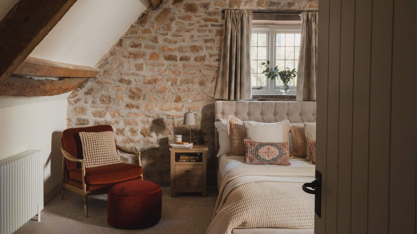 A sanctuary for slumber with dark rustic beams and a romantic vaulted ceiling, the first bedroom space promises a subtle neutral palette