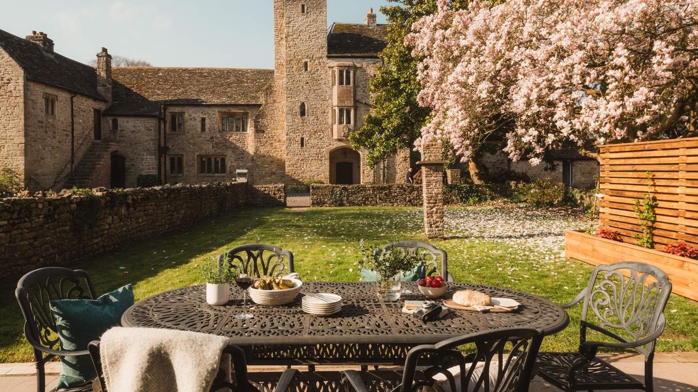 Gather outside for alfresco gatherings around the antique dining table with six chairs