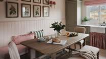 Gather for mealtimes around the extendable farmhouse style kitchen table, with upholstered banquet seating, chairs and a bench