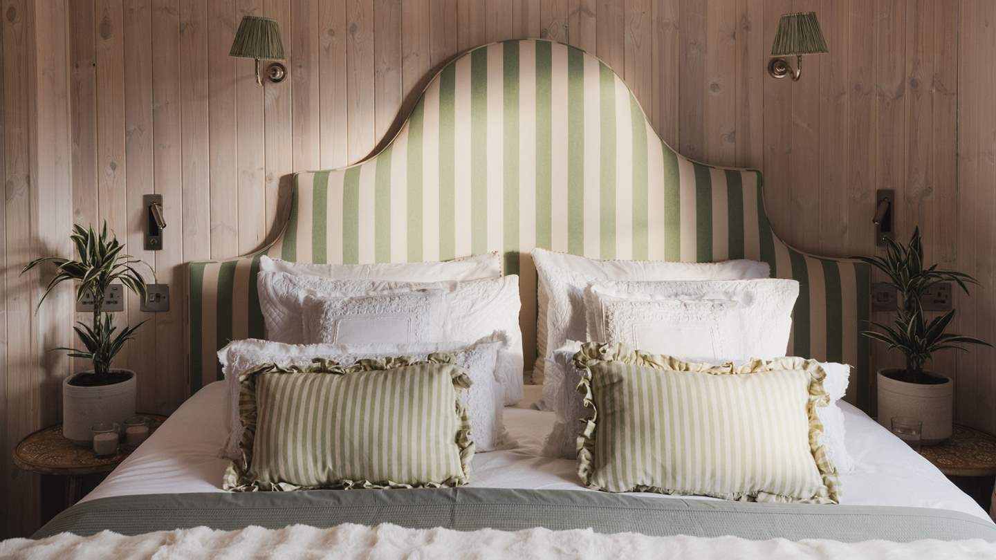 With warm, limewashed wooden panelling on both the walls and ceiling, the third bedroom can be found on the ground floor