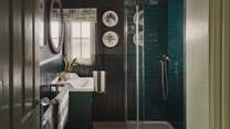 Opposite the third bedroom, you will find the family shower room in rich verdant shades