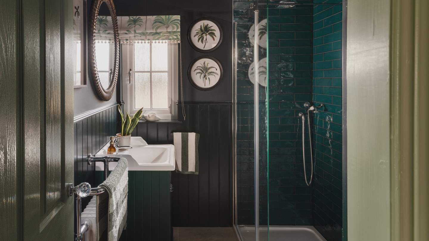 Opposite the third bedroom, you will find the family shower room in rich verdant shades