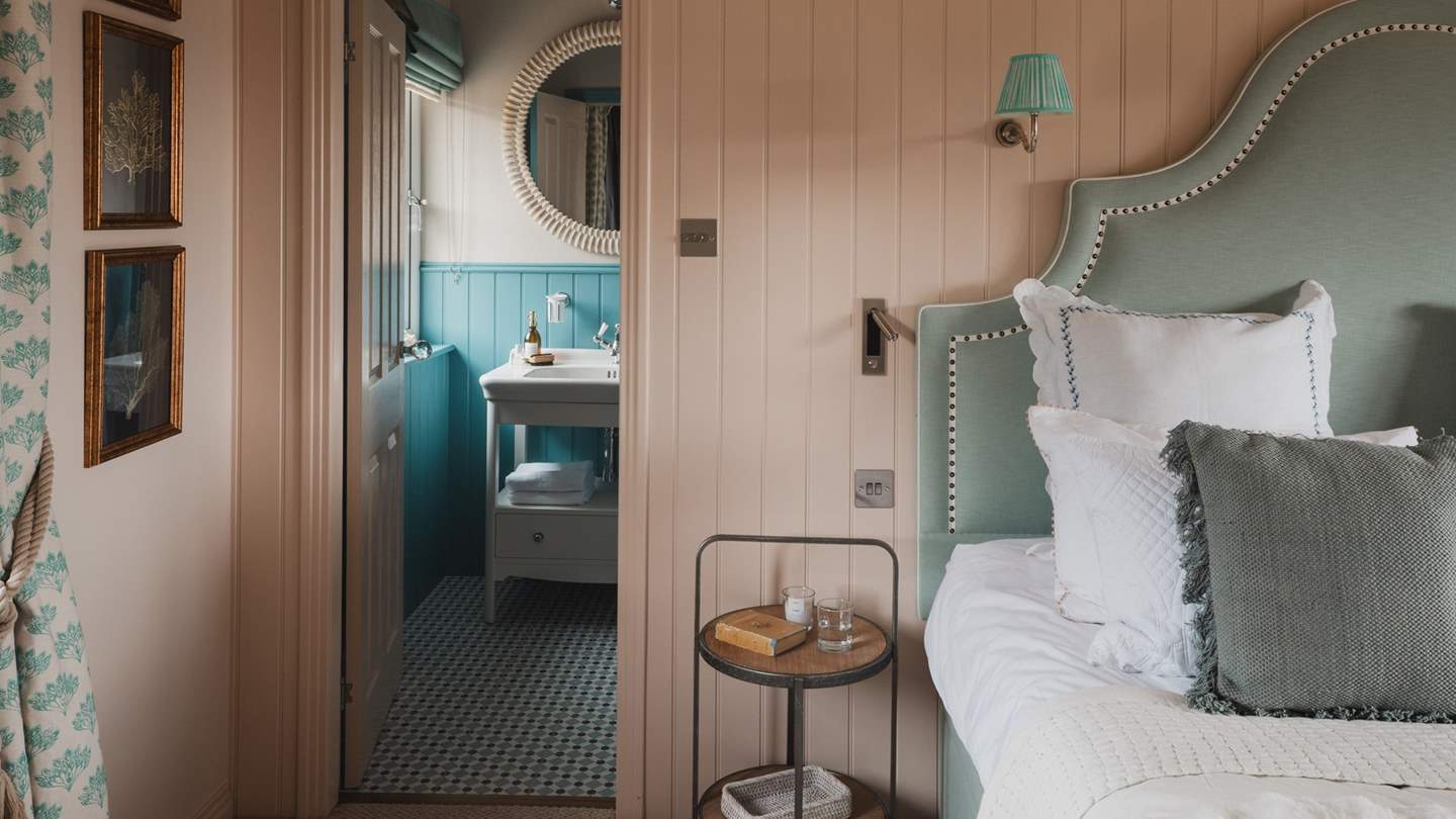 Awash with colour, with blue panelling and tiles in complementary shades, uncover the ensuite bathroom