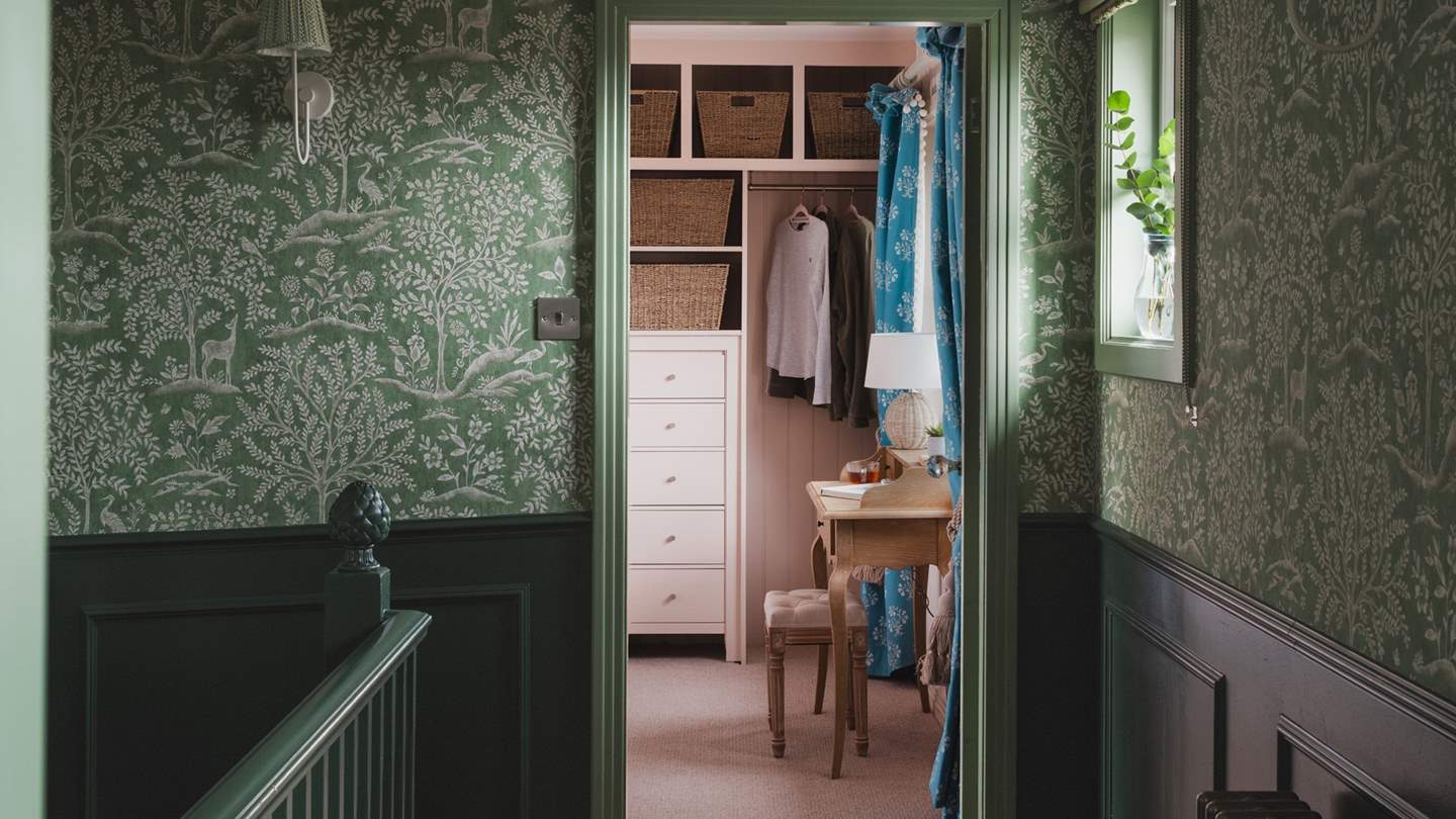 Nina Campbell’s foret wallpaper in emerald shades adorns the hallway and guides you to the first and second bedrooms on the first floor