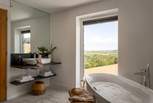 A freestanding bathtub awaits for bubble-topped self-care moments