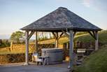 At the rear of the garden, a spellbinding slate-topped wooden pergola houses a cedar, wood-fired hot tub and a built-in barbeque