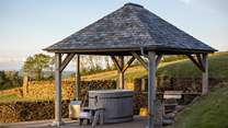 At the rear of the garden, a spellbinding slate-topped wooden pergola houses a cedar, wood-fired hot tub and a built-in barbeque