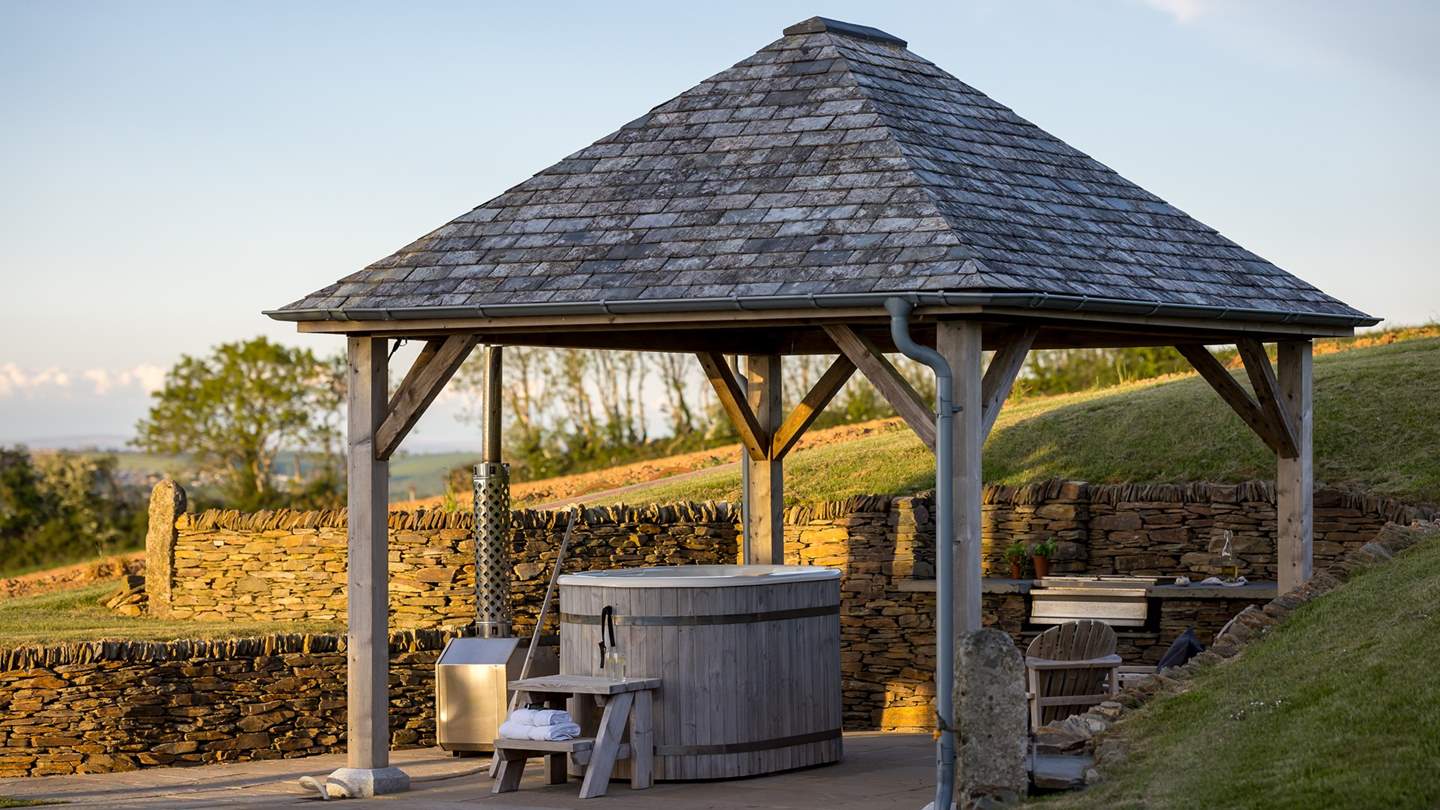 At the rear of the garden, a spellbinding slate-topped wooden pergola houses a cedar, wood-fired hot tub and a built-in barbeque