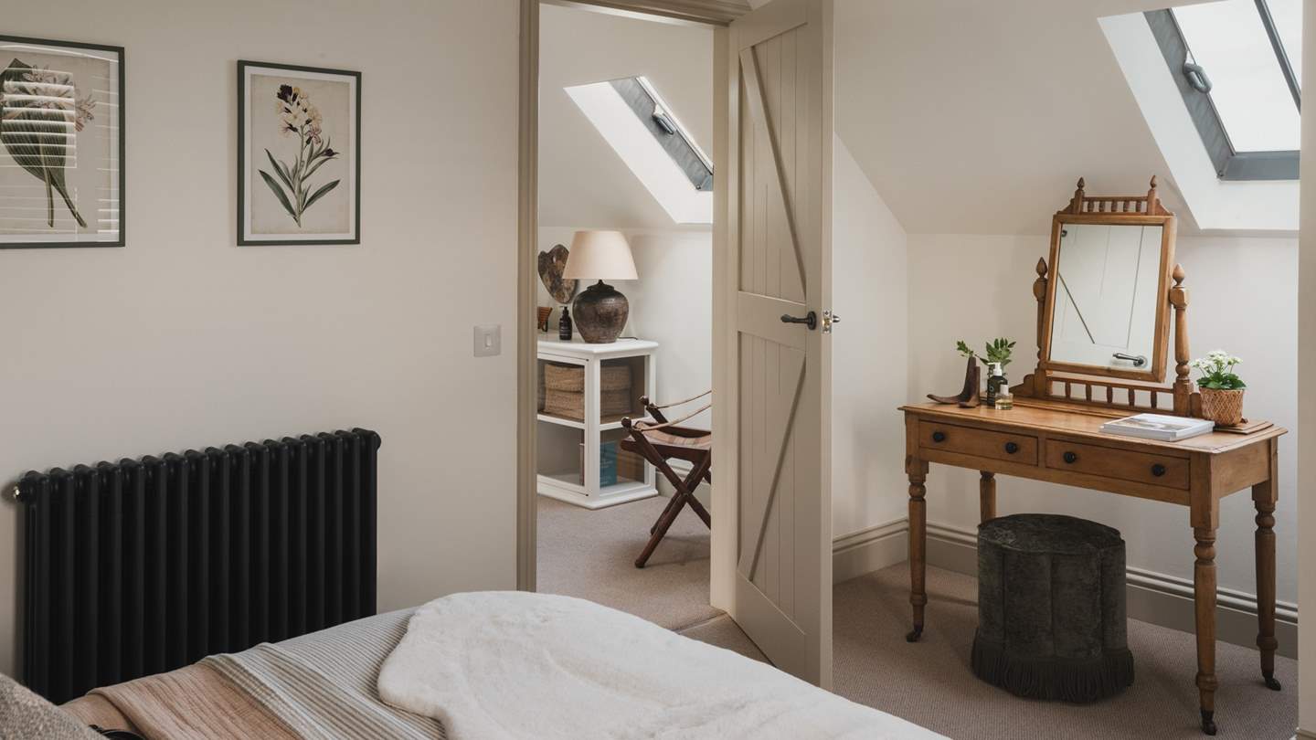 A Victorian pine dressing table rests beneath the Velux window, offering the perfect light-filled setting to get ready for the day