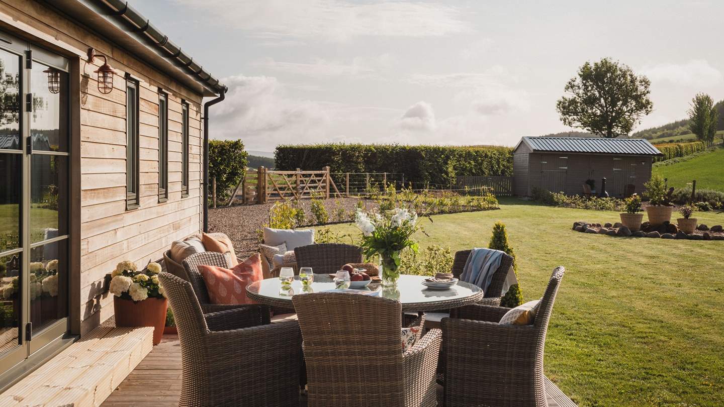 Step out onto a decked patio area, where you’ll find seating for six around a circular table 