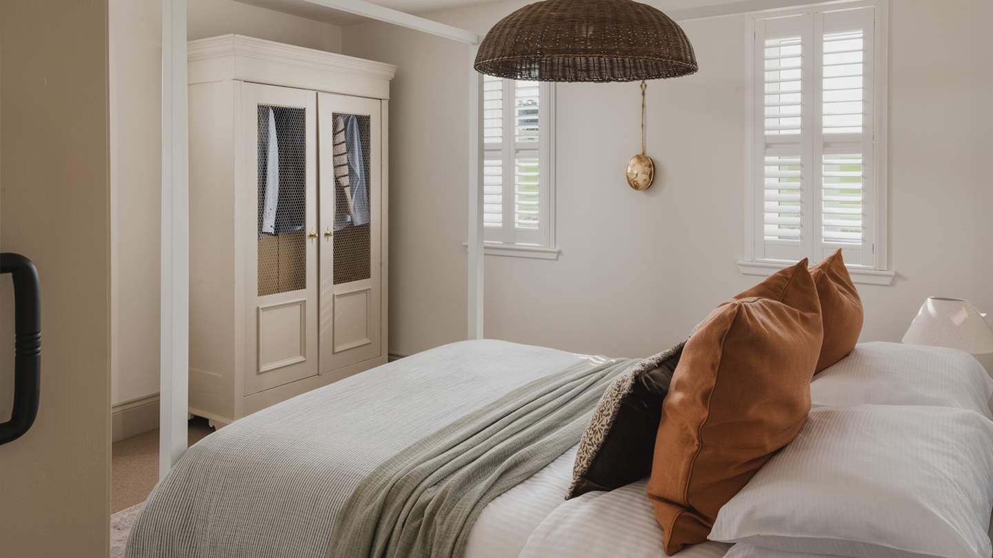 A harmony of modern minimalism and antique charm, we just love the four-poster king size bed and antique armoire