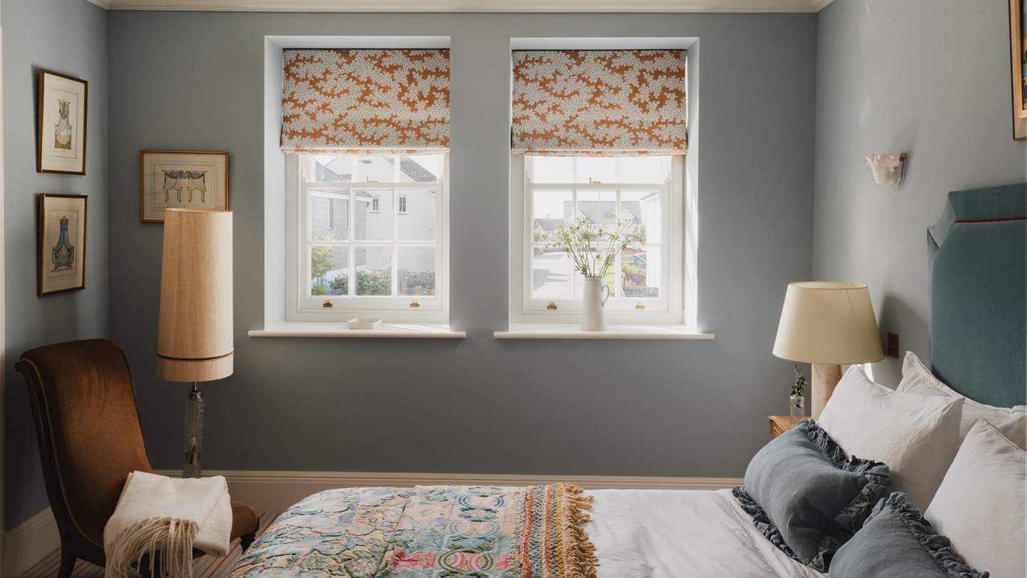 Soothing in blue shades with mahogany accents, the fifth bedroom features a striking upholstered headboard and king-sized bed with a Soho Home mattress