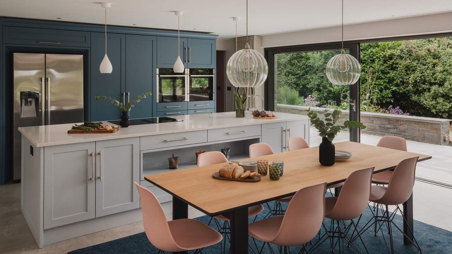 For dreamy indoor-outdoor living, floor-to-ceiling glass doors, lead to the wraparound stone terrace