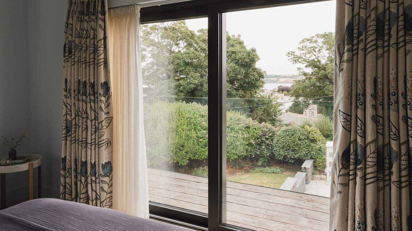 Via sliding doors awaits a glass balcony, where you can indulge in your morning coffee beside dreamy views of Carrick Roads estuary and beyond