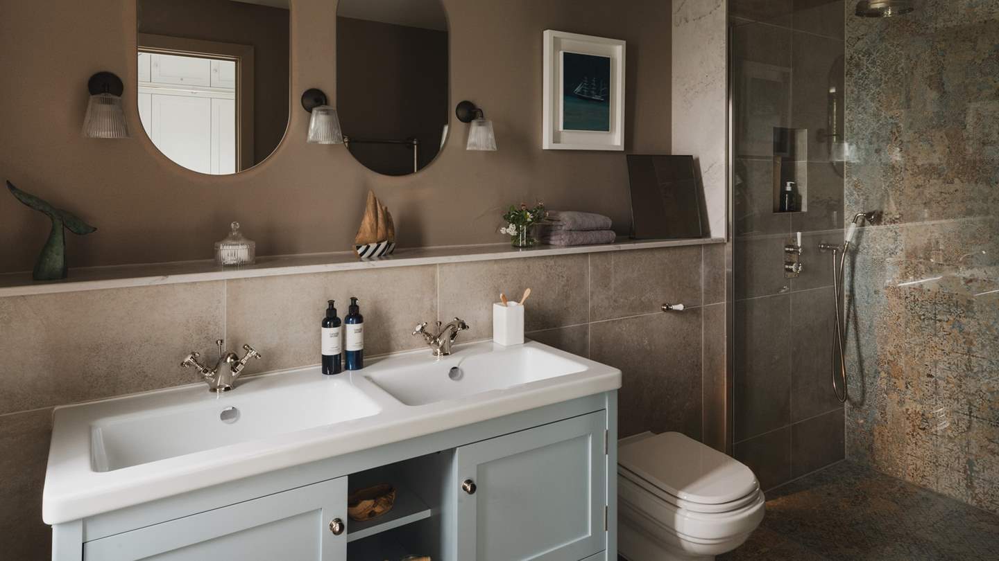 Discover another luxurious earth-toned en suite, complete with a walk-in shower with rainfall head...