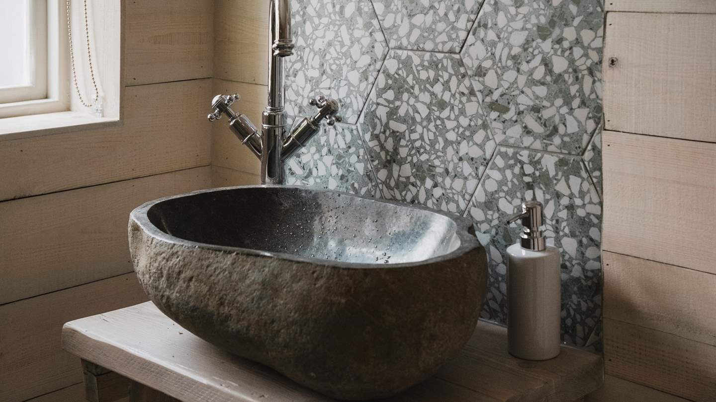 Rustic touches and natural stone features create an inviting space for self-care rituals 