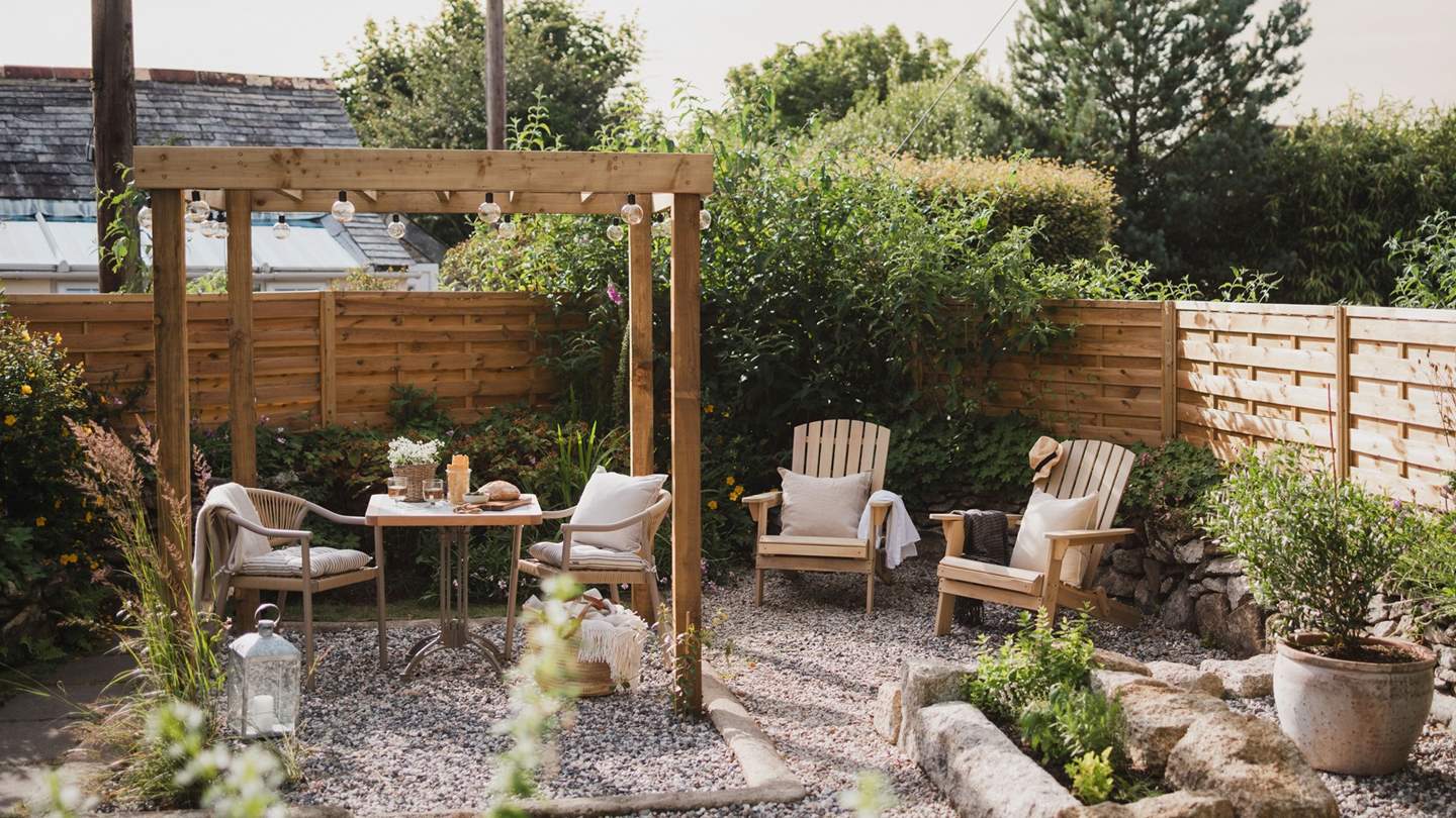 A dining table for two rests beneath a pergola, promising shade for outdoor dining scenes