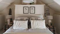 Uncover a king size bed swathed in cushions and throws in natural tones