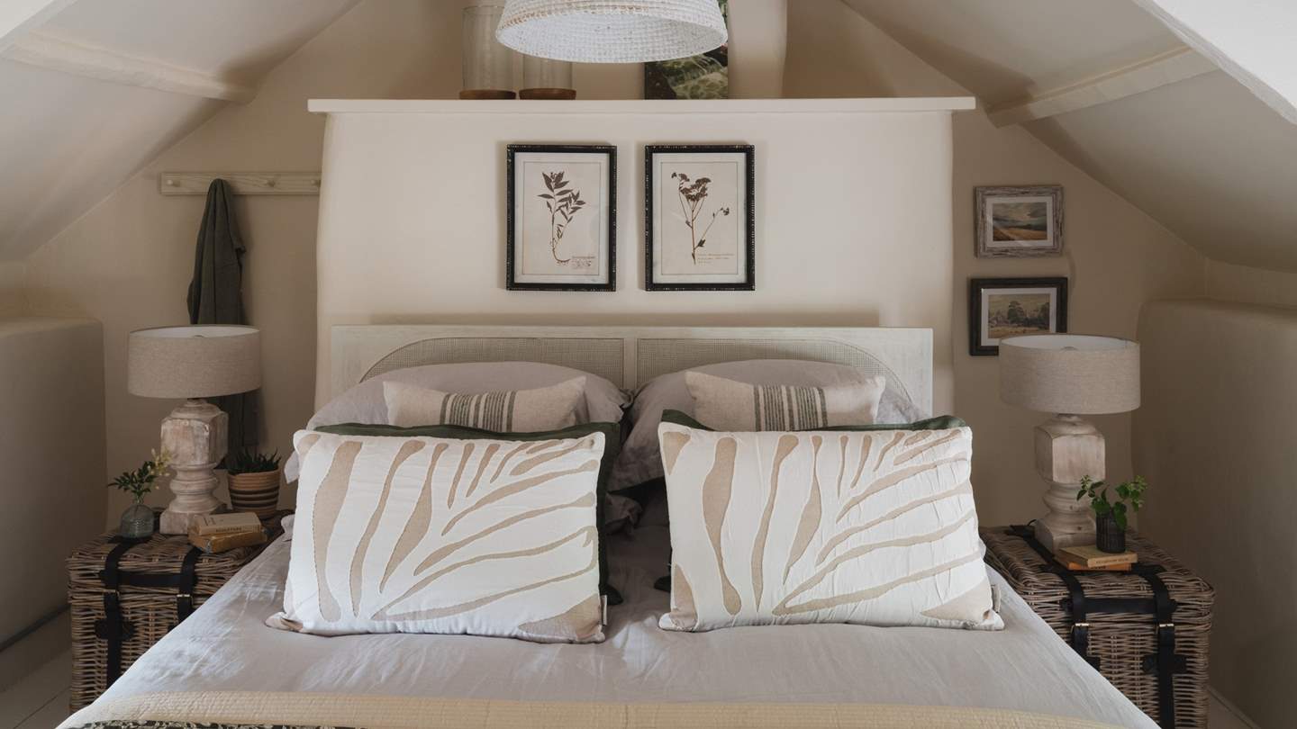 Uncover a king size bed swathed in cushions and throws in natural tones