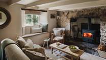 Exposed beams and a large granite fireplace create the cosiest ambiance in the inviting living space