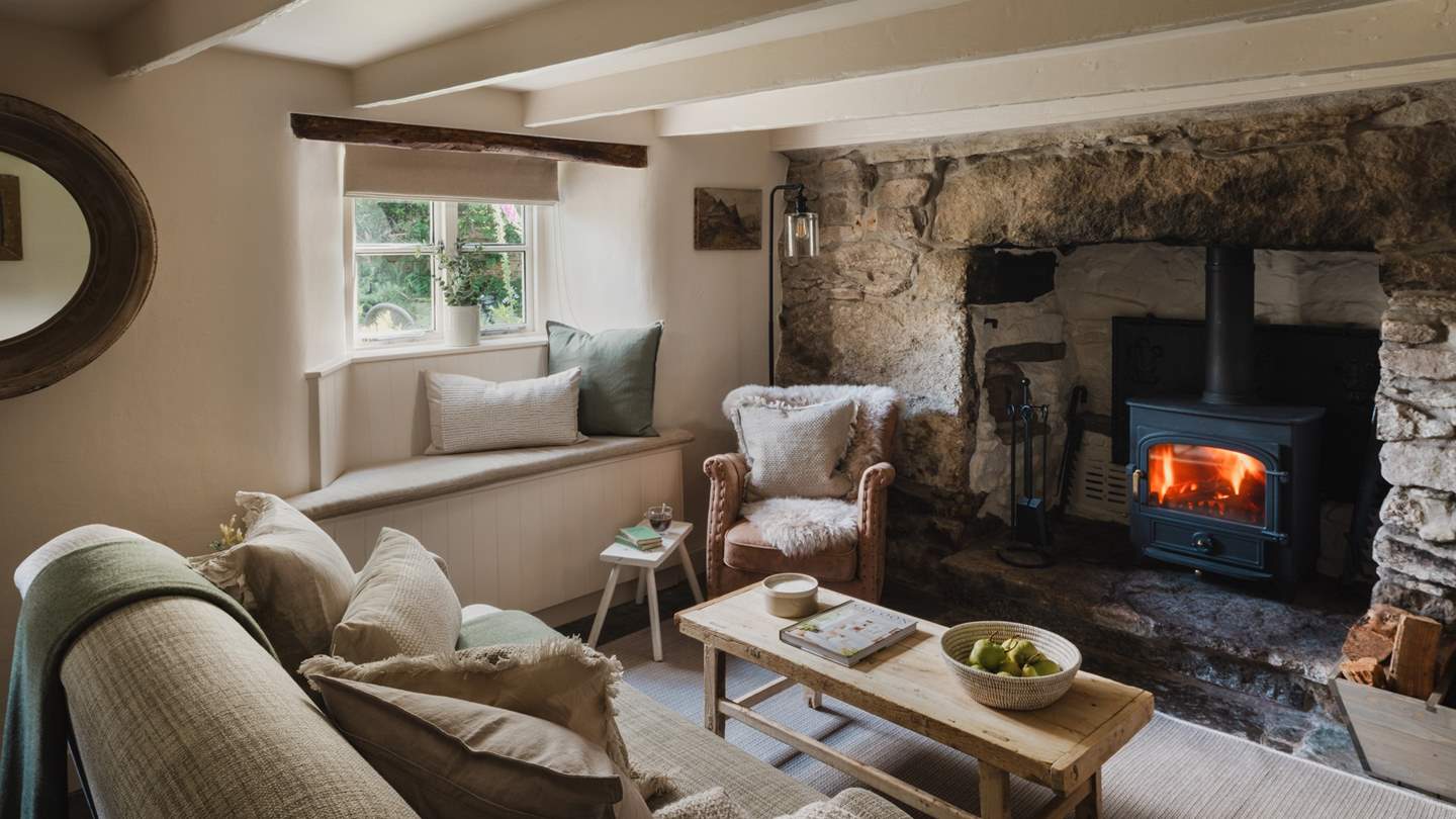 Exposed beams and a large granite fireplace create the cosiest ambiance in the inviting living space