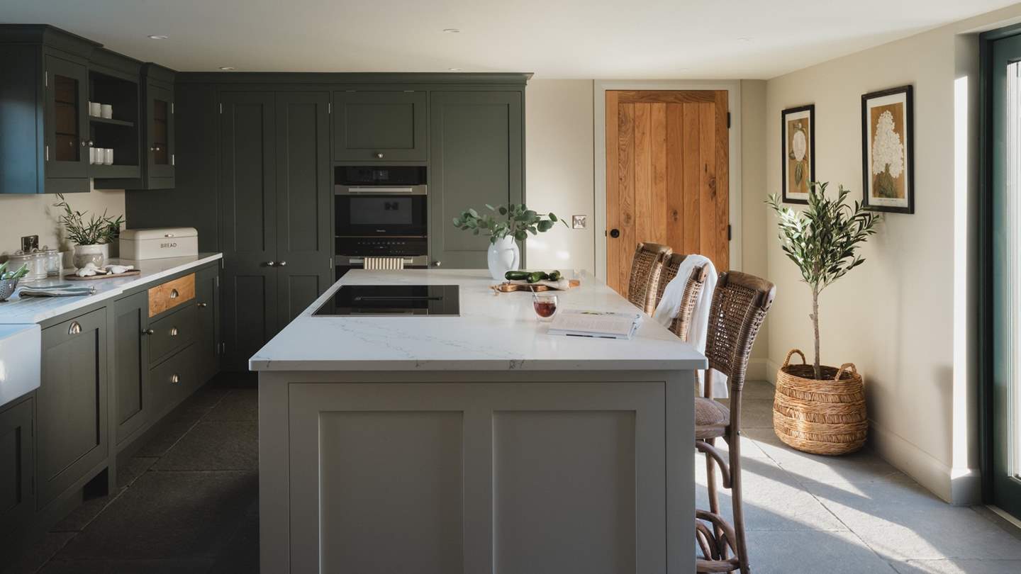 Step into the spacious kitchen and dining area, where a farmhouse style kitchen and island reside in rich earthy tones