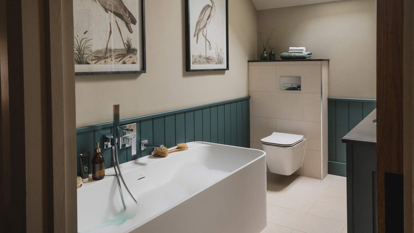 The second and third bedroom share access to the family bathroom, beautifully panelled in soothing shades of teal