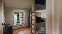 The sweetest space for little ones to rest, the second bedroom features twin bunk beds with cosy sleeping nooks and built-in TVs