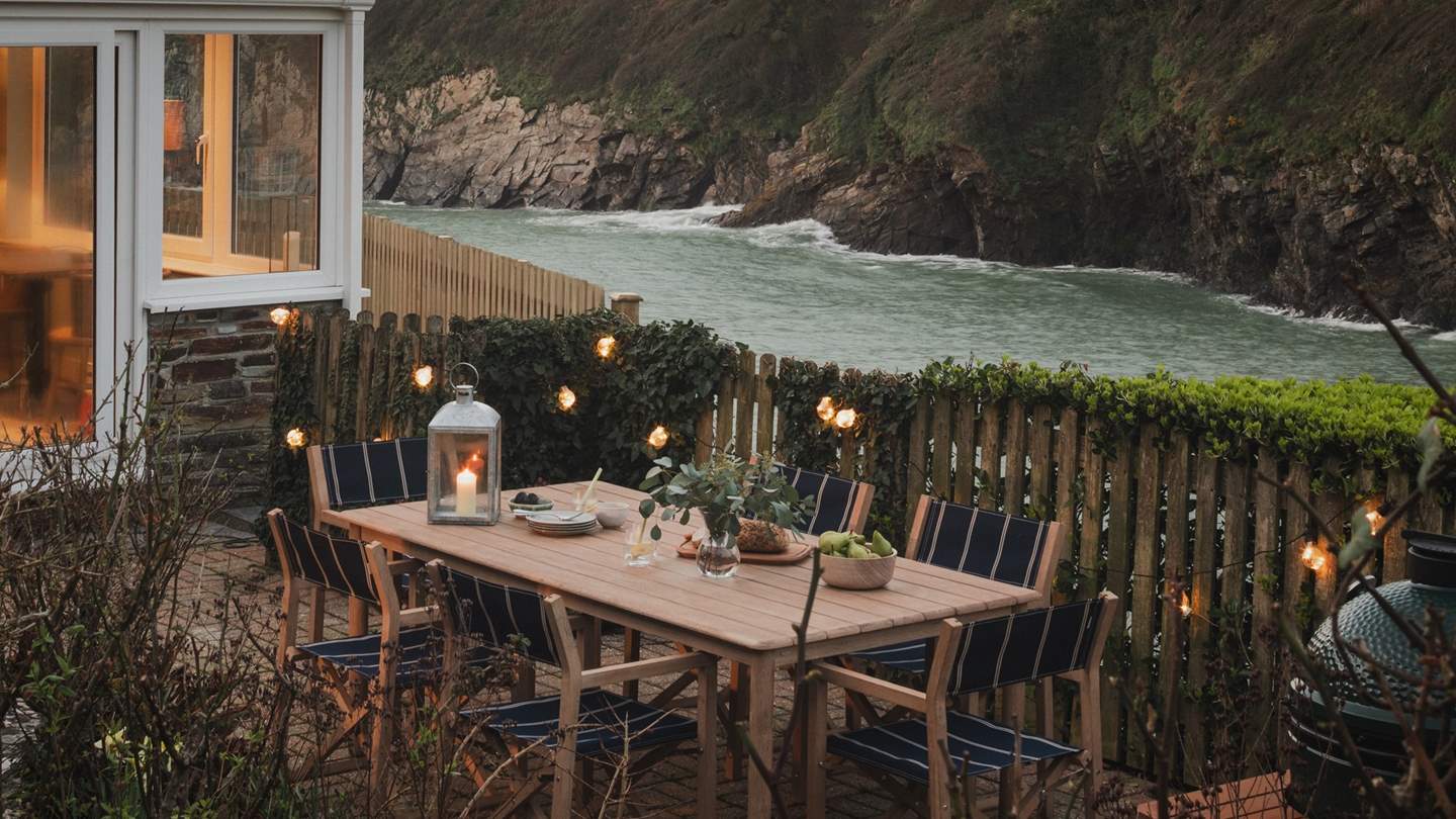 Outside, a sun-soaked garden and terrace overlook the cove