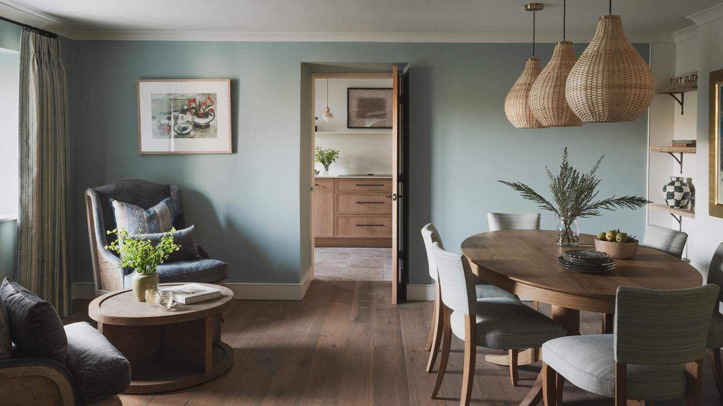 Adjoining the open-plan living area, an oval dining table seats six with upholstered chairs