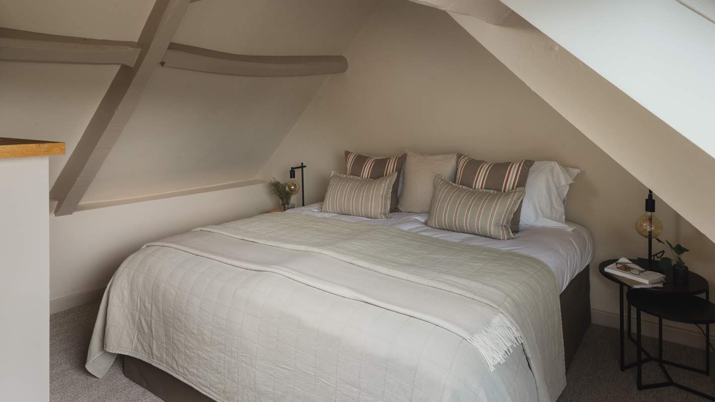 Nestled within the eaves is the master bedroom featuring a super king bed