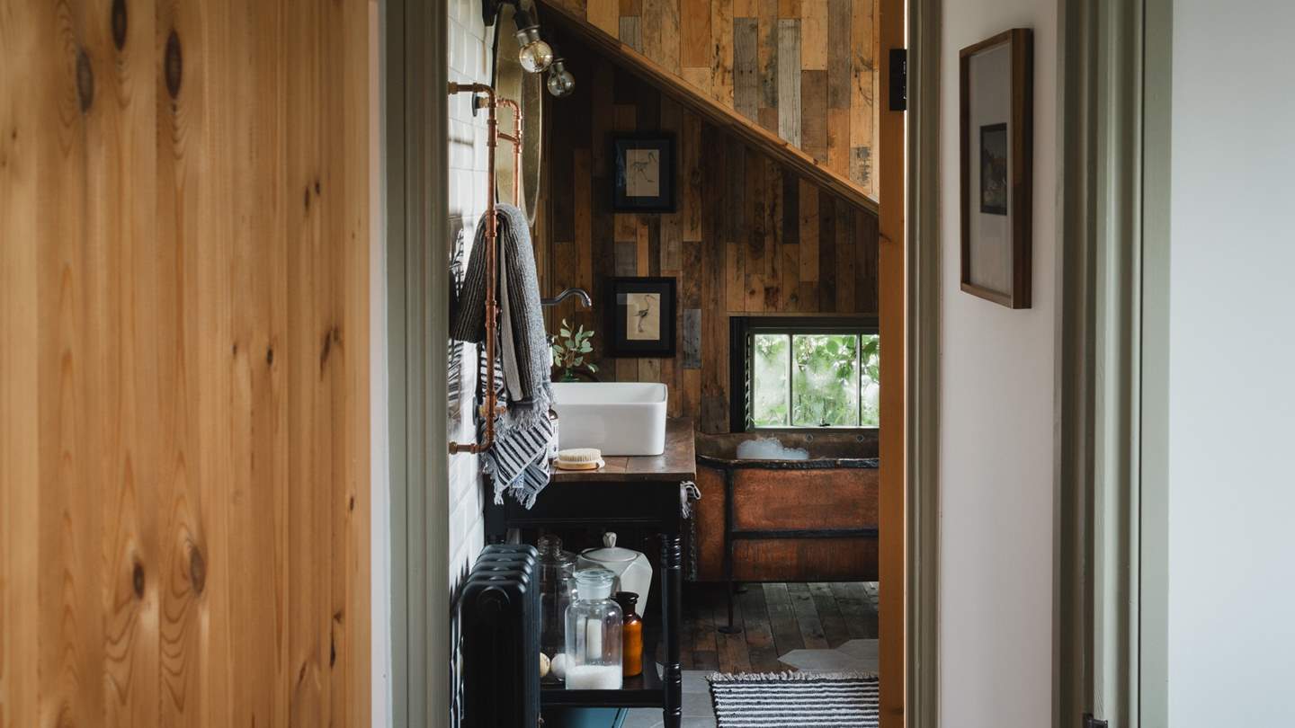 The bathroom is a sanctuary for self-care rituals, where a French antique copper bathtub takes centre stage, 