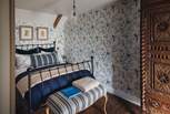 Wrapped in stunning blue Chinoiserie wallpaper, this space harmonises cottage cosiness and palatial opulence 