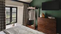 For stowing belongings, you will find an open wardrobe, and a chest of drawers in harmonious shades