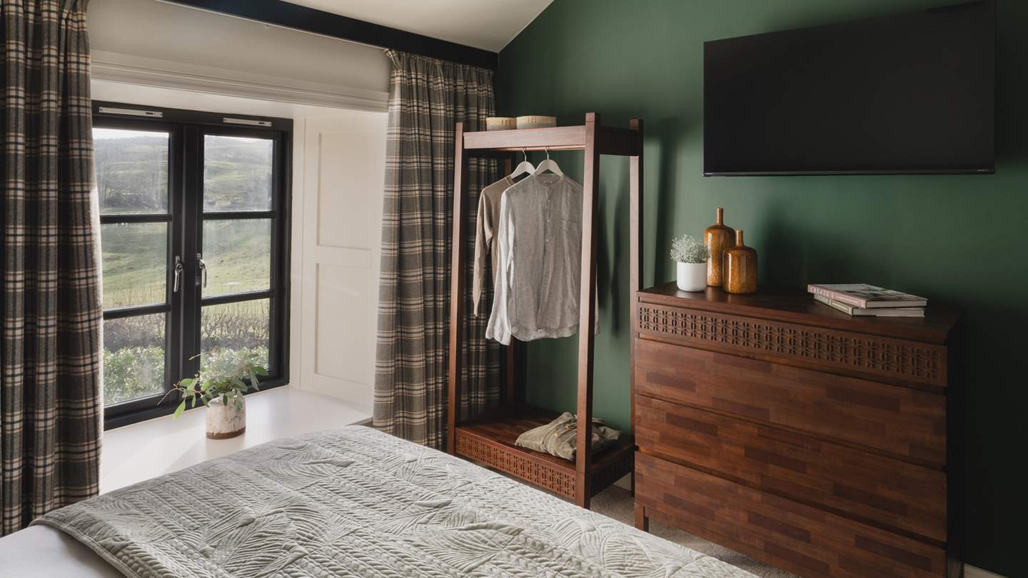 For stowing belongings, you will find an open wardrobe, and a chest of drawers in harmonious shades