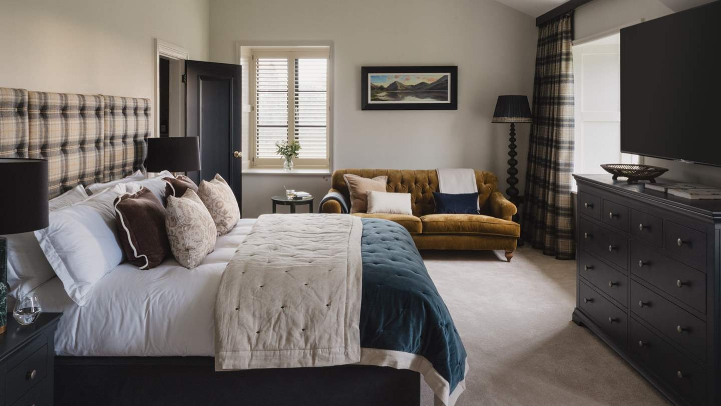 At the far side of the room, a sofa in sumptuous ochre tones beckons