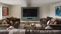 The media room is a soothing space to retire, with three sumptuous sofas centred before an 85” Smart TV