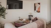 Uncover an additional living space within the games room, with a comfortable sofa and large Smart TV