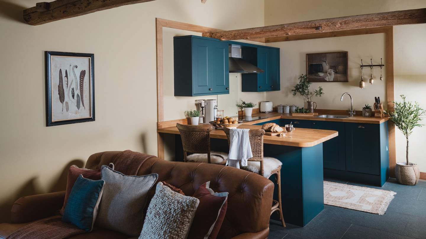 The kitchen is a charming space for creating and dining on the breakfast bar, with two wicker stools draped in sheepskins