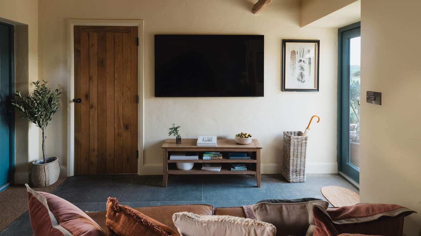 Settle on the tan leather sofa for movie nights on the expansive Smart TV